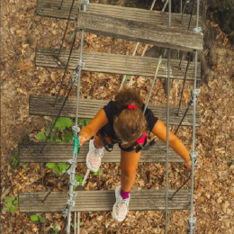 enfant traversant un pont suspendu en pleine nature au parc de loisirs Bosdarros Aventures